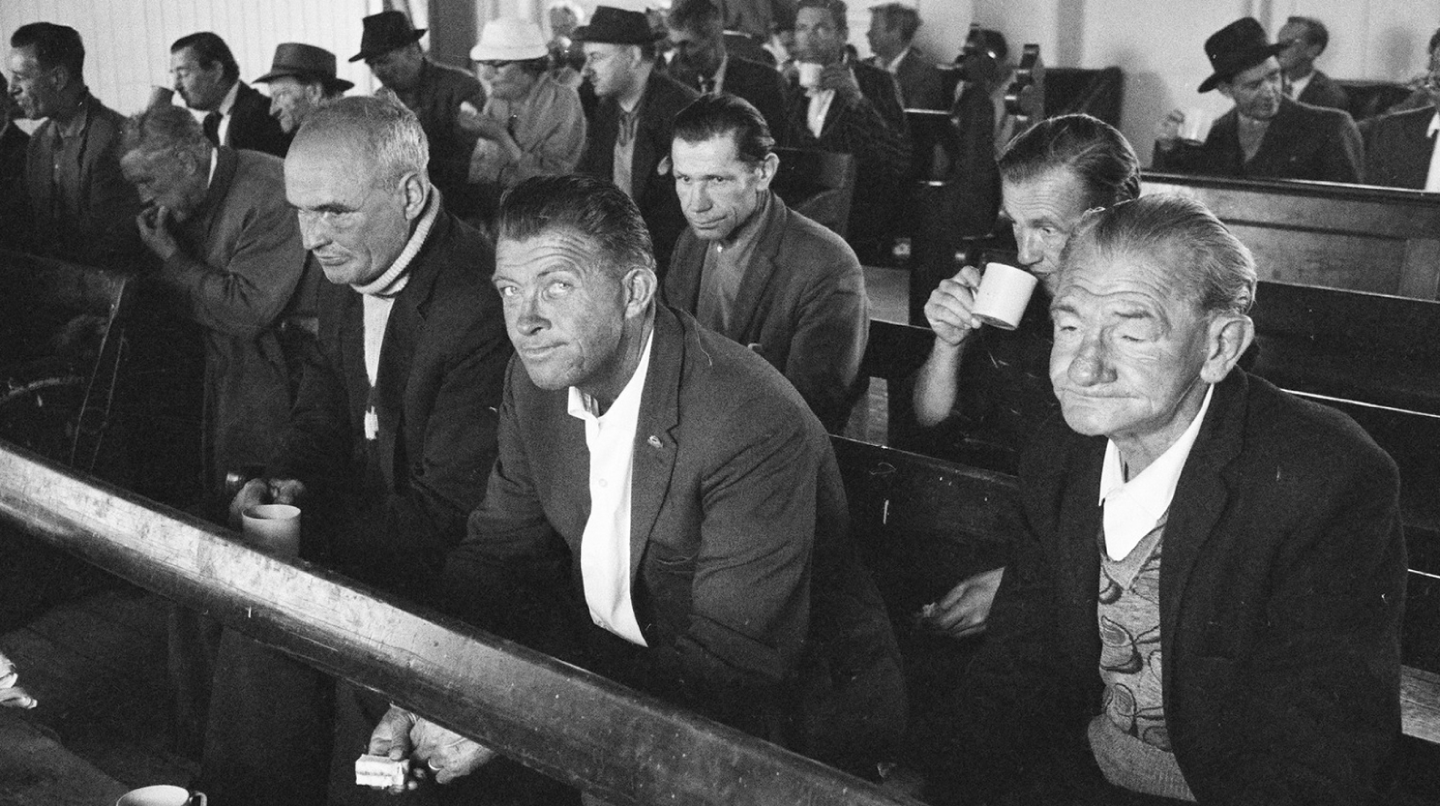 Black and white photograph of men in suits sitting on church pews. Photograph taken by Alan K Jordan.